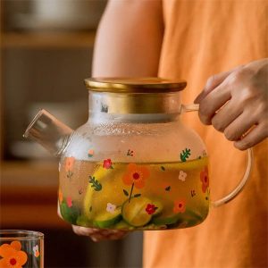 Théière en verre avec couvercle doré et motifs fleurs