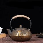 Théière en fonte dorée avec motif de bambous
